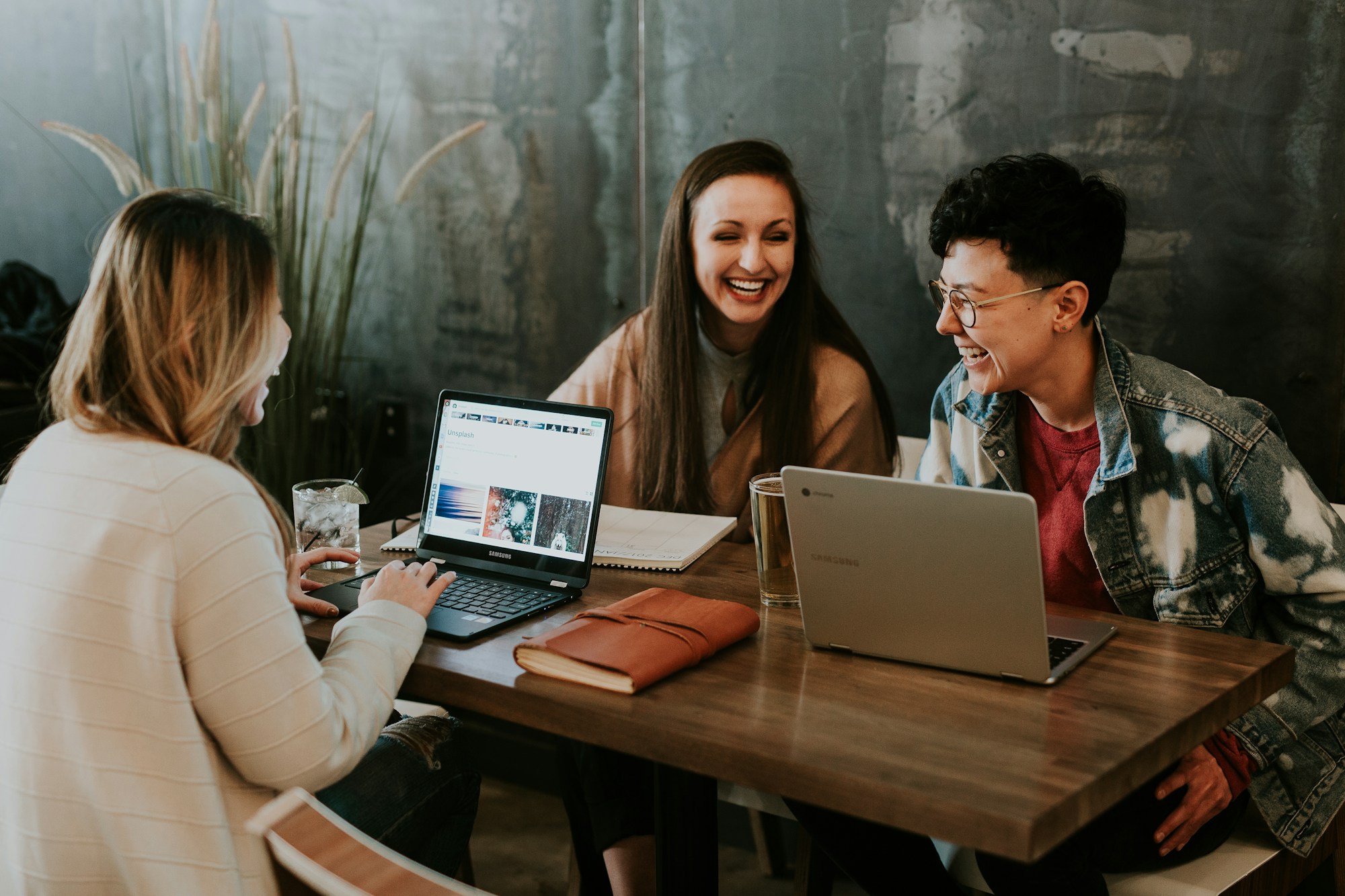 Marketing professionals gathered around a table with laptops and notes, working together to refine strategies and enhance project outcomes.